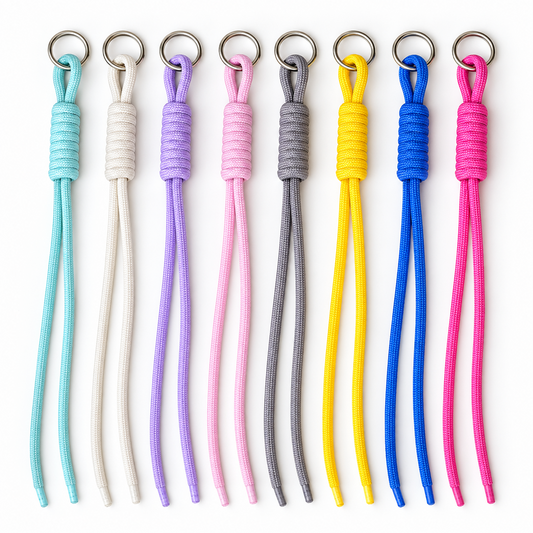 Eight knotted paracord keychains in assorted colours with metal split rings and two loose cord ends
